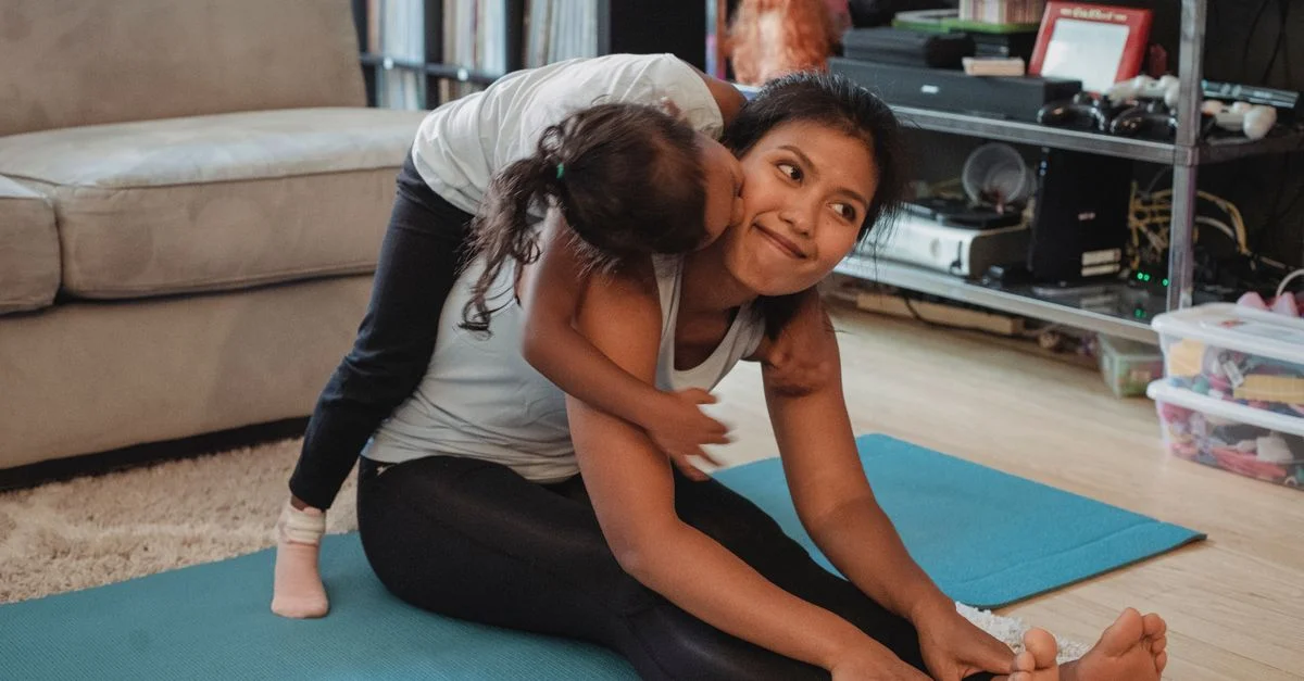 Une mère et sa fille profitant d'une séance d'exercice ludique à la maison sur un tapis de yoga.